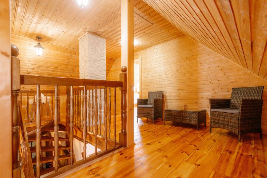 Galerie se dvěma ratanovými křesly nad schodištěm